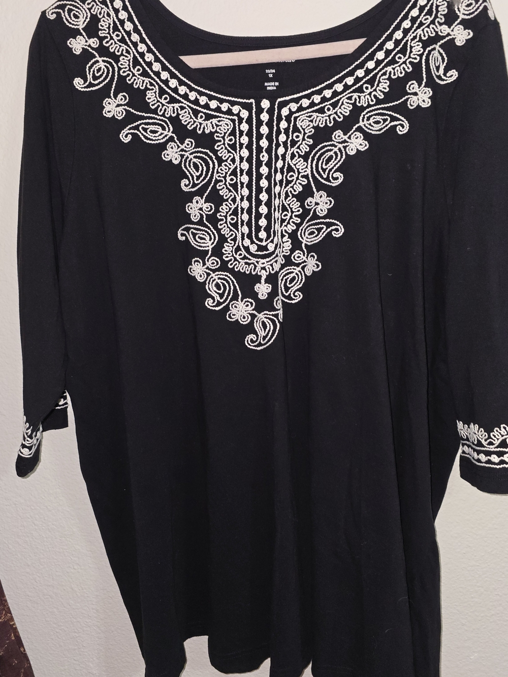 Woman Within Black Tunic with White Embroidered Neckline